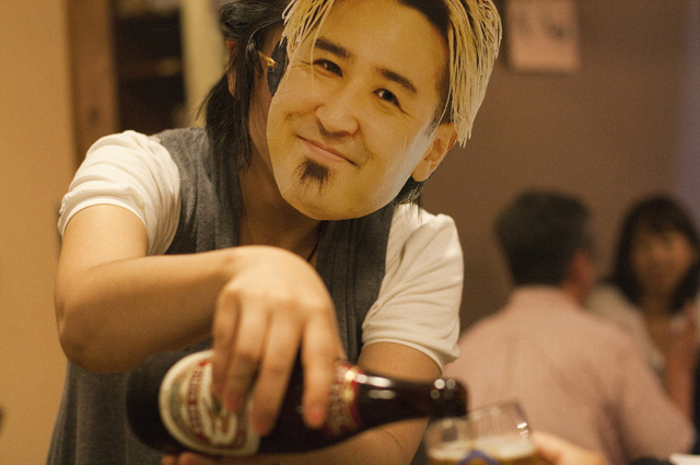 お酌をしているのは、鷹野さん…!?　いや違います。正しくは、鷹野さんのお面をつけたニセ者です(笑)。